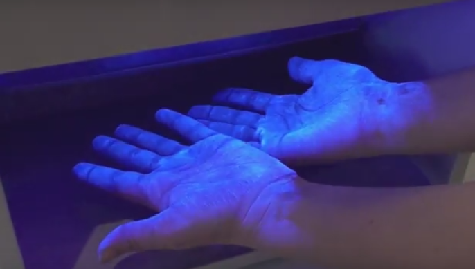 Hygienekontrolle mit Schwarzlicht zur Kontrolle der Händedesinfektion oder Flächen